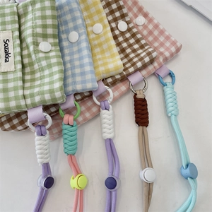Vue détaillée de pochettes en tissu à carreaux colorés avec boutons et cordons réglables