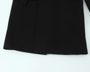 Detailed close-up of high-quality black wool coat fabric texture and precise stitching line