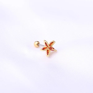 Clou d'oreille étoile de mer dorée avec zircons orange et fermoir à vis sur soie blanche