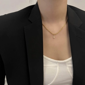 Détail du pendentif lettre L dorée avec oxydes de zirconium sur chaîne torsadée