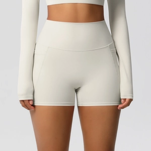 Gros plan sur le short de yoga beige à taille haute avec poches latérales et tissu élastique