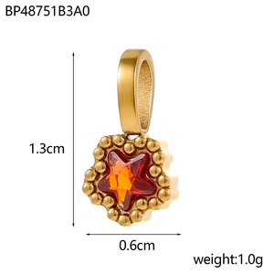 Macro shot of 1.3cm gold star pendant with orange-red zircon stone and bead edging