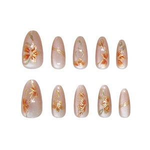 Cat eye press-on nails with handmade floral art and golden enamel details on almond shape