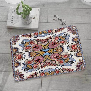 Detail der böhmischen Mandala-Flanellmatte mit verstärkten Kanten auf grauem Holzboden