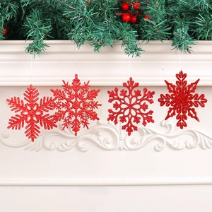 Set of four 10cm red glitter snowflake ornaments hanging on a festive Christmas garland