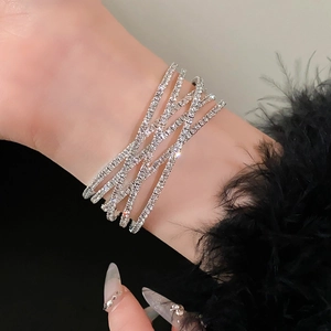 Detail van de meerlaagse kruislingse zilveren armband met zirkonia steentjes