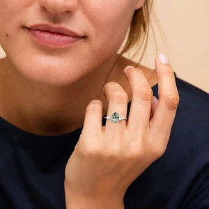 Elegant silver ring with marquise-cut moss agate stone and side diamonds on female finger