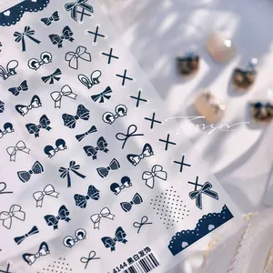 Macro view of model 4144 black and white bow nail stickers with lace and polka dot details