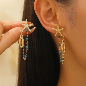 Ocean style gold starfish earrings with shell charms and blue beads on model