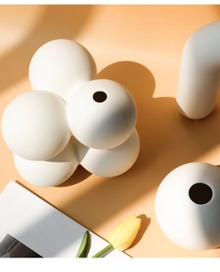 Moderne weiße matte Keramikvase im Kugeldesign mit kunstvollem Schattenwurf