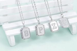 Detail of silver letter pendants B, P, Z, G with cubic zirconia stones on O-chains