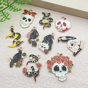 Detailed flat lay of gothic gold enamel pendants with skull, raven, and crescent moon motifs