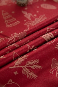 Detail of red Christmas tablecloth with jacquard weave tree and bell patterns