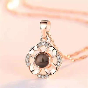 Detailed macro view of rose gold flower pendant with small crystals and projection stone