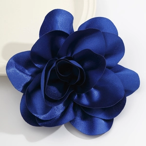Macro shot of dark blue satin flower brooch showing layered petals and silky texture