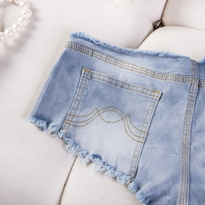 Detail der hellblauen Denim-Shorts mit Wellennaht und ausgefransten rohen Saumkanten
