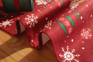 Detailed view of red Christmas table runner with festive snowflakes and linen texture