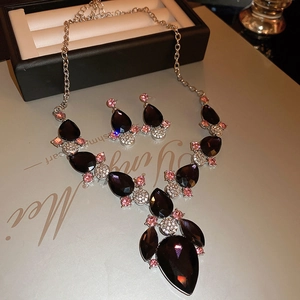 Macro shot of luxury drop jewelry set with deep purple gems and pink zircon accents