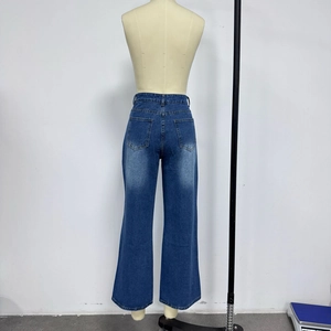 Détail d'un jean taille haute à jambe large avec poches arrière et délavage bleu clair
