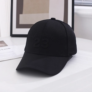 Close-up of black cotton baseball cap with number 23 embroidery in modern indoor setting