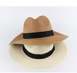 Nahaufnahme von geflochtenen Strohhüten in Braun und Beige mit schwarzen Zierbändern