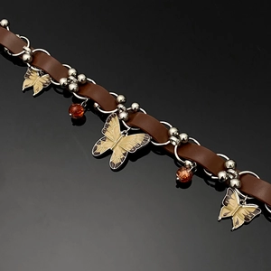 Detail of brown leather choker with yellow enamel butterfly charms and amber beads