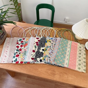 Vue à plat de sacs fourre-tout en toile florale avec poignées en coton sur bois