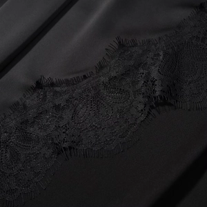 Vue détaillée de la bordure en dentelle noire et du tissu satiné lisse de la robe