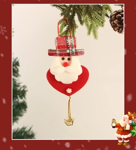 Dettaglio di Babbo Natale in peluche con base a cuore rosso e campanellino d'oro sull'albero