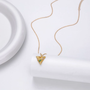 Detailed view of a gold triangle pendant set with green, purple, and yellow gemstones