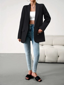Blazer cintré noir pour femme porté avec un jean bleu clair et un haut court blanc chic