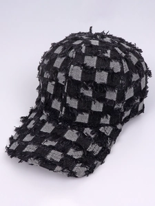 Detail of distressed checkered baseball cap showing frayed edges and denim texture