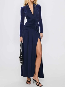 Detail view of the deep blue velvet dress featuring a deep V-neck and ruched waist details