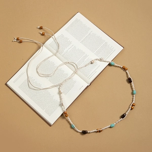 Détail d'une chaîne de taille bohème faite main avec glands sur fond de livre