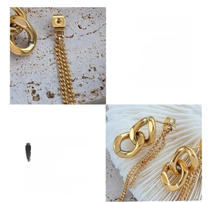 Detailed view of asymmetric 18k gold plated titanium steel chain earrings texture