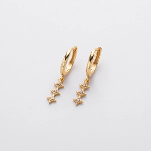Détail de boucles d'oreilles créoles en argent S925 doré avec pendentifs étoile et diamants