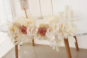 Close-up of artificial rose floral runner with cream and caramel flowers for wedding decor