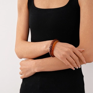 Close-up of vintage amber acrylic twisted bangle with retro spiral marble pattern