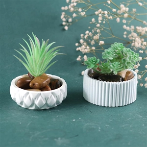 Set of two mini artificial succulents in geometric and striped white ceramic pots