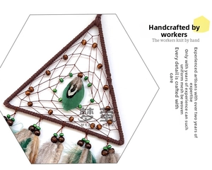 Close-up of handmade triangular dream catcher with natural feathers and wooden beads