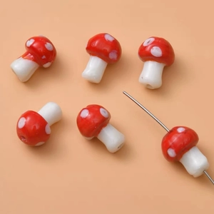 Macro shot of red handmade glass mushroom beads with white spots for DIY jewelry
