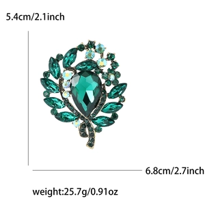 Luxury green glass brooch with rhinestones measuring 5.4cm by 6.8cm on white background
