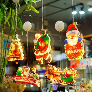Close-up of LED Christmas suction cup lights with Santa and snowman on window glass