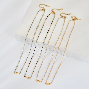 Détail de colliers dorés avec pendentifs œil et micro-perles de couleurs variées