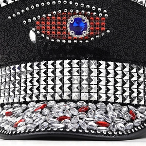 Detail of captain hat with black sequins, silver studs, and a jeweled blue eye centerpiece