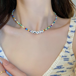 Detail shot of a handmade beaded necklace with colorful beads and SMILE letter charms