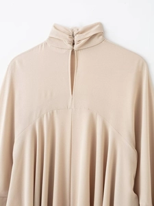 Detail of beige high-neck top featuring elegant pleated layers and a teardrop cutout back