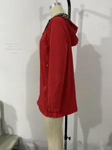 Detail der roten Kapuzenjacke mit Leopardenmuster-Futter und vertikaler Reißverschlusstasche