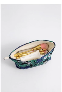 Detailed macro shot of vintage floral jacquard fabric and large makeup bag interior
