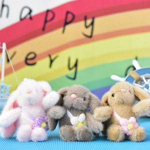 Macro view of three cute plush rabbit pendants in pink, grey and brown